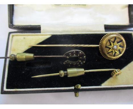 A yellow  metal and seed pearl stick pin, a brass and red stone horseshoe stickpin and a 9ct gold head with diamond chip stic