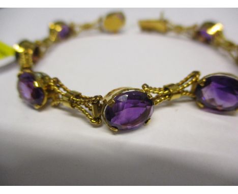 A yellow gold and amethyst bracelet set with eight stones and rope twist style links stamped 750 