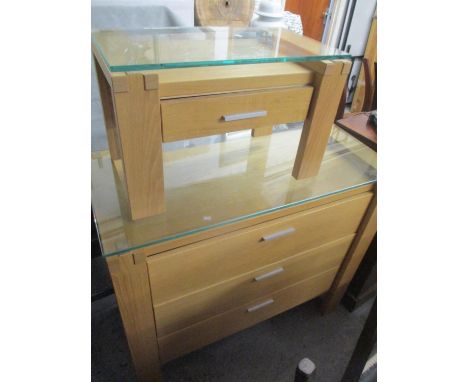 A modern light oak chest of three long drawers and having a glass top, 36" h x 41"w, together with a matching bedside table, 