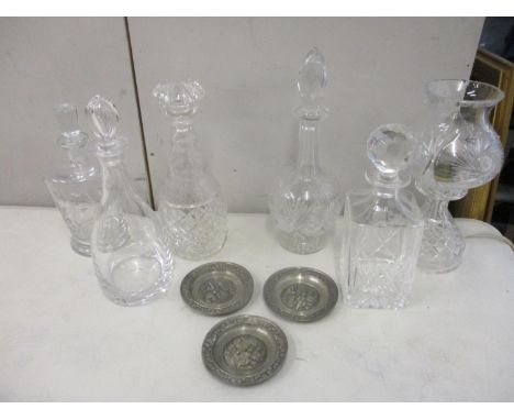 Five modern cut glass decanters and a cut glass lamp, along with three pewter dishes 