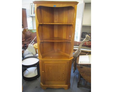 An Ercol pine corner cabinet having open shelves above a single cupboard door, 72"h x 30"w 
