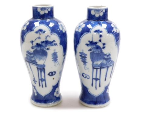 A pair of early 20thC Chinese blue and white baluster vases, decorated with reserves of interior objects against a blue groun