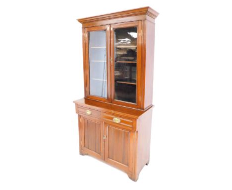 A Victorian mahogany cupboard bookcase, the top with a moulded cornice above two glazed doors enclosing an arrangement of she