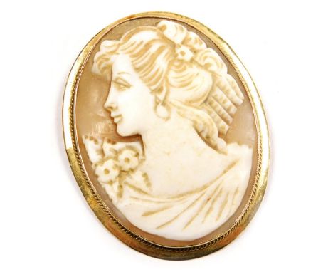 A 9ct gold and shell cameo brooch, bust portrait of a lady with floral corsage, 42mm high x 37mm wide.