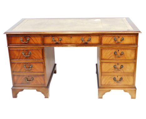 A flame mahogany twin pedestal desk, with a tooled brown leather top over one long and eight short drawers, raised on bracket