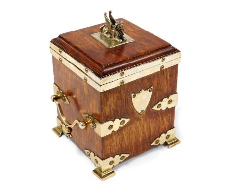 A Victorian oak and brass mounted tea caddy, of rectangular section, with a sphinx finial to the hinged lid, opening to revea