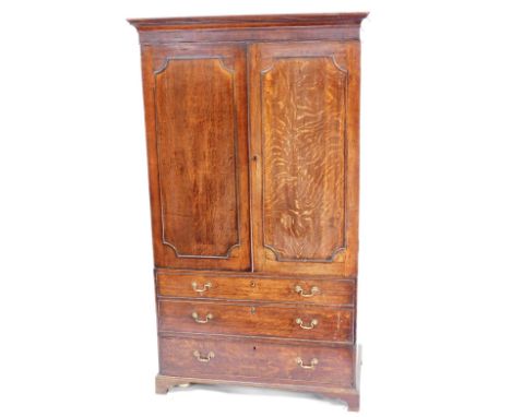 A George III oak linen press, converted to a wardrobe, the out swept pediment over a pair of panelled doors over two dummy an
