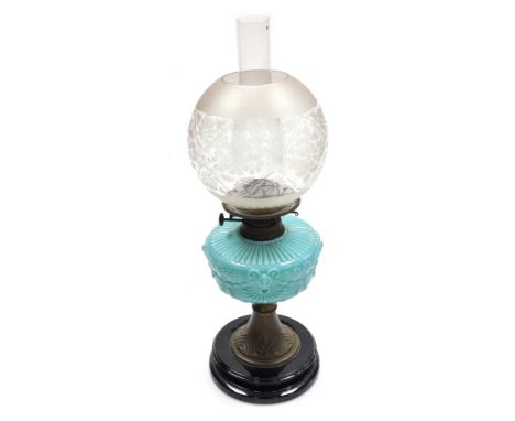 A late 19thC oil lamp, with a clear and etched glass globular shade, with a blue vaseline glass central reservoir, raised on 
