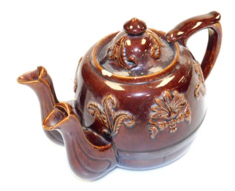 A late 19thC Rockingham brown glaze double spouted teapot, decorated in relief with fleur de lys, further flowers, sprigs, et