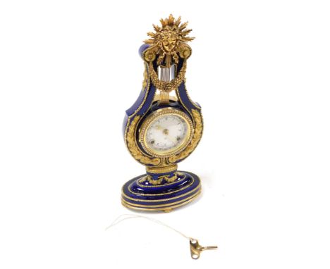 A V &amp; A Louis XIV style porcelain and brass mounted mantel clock, circular dial bearing Roman numerals and the months of 