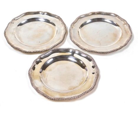 Three Edwardian silver dinner plates by R &amp; S Garrard &amp; Co, of Georgian design, with scalloped and gadrooned borders,