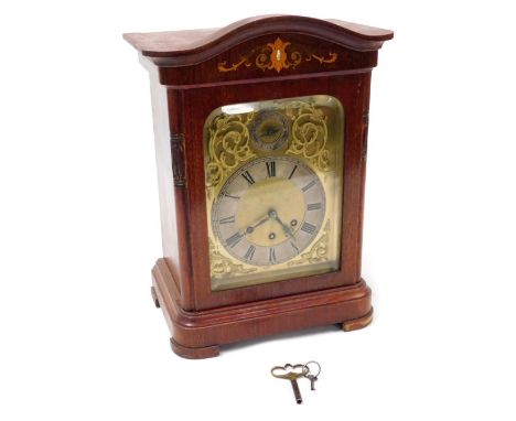 An early 20thC German mahogany cased mantel clock, the rectangular brass dial with foliate scroll spandrels, silvered chapter
