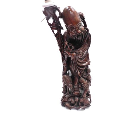 A Chinese hardwood carving of Shao Lao, converted to a table lamp, 62cm high overall.