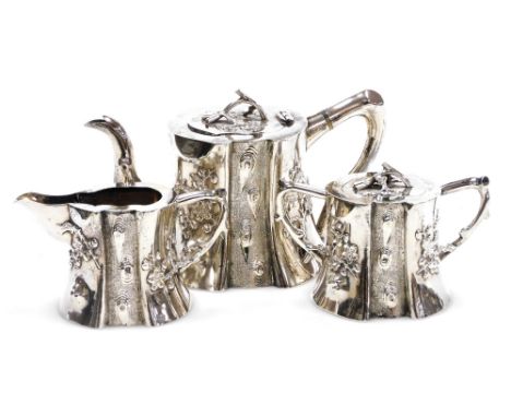 A 19thC Chinese export silver three piece tea set, of naturalistic trunk form, embossed in high and bas relief with prunus bl