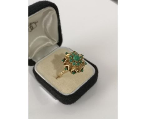 A VINTAGE LADIES 9CT GOLD RING IN THE FORM OF A FLOWER, FITTED WITH VARIOUS JADE STONES. [6.57GRAMS] [RING SIZE S]. 