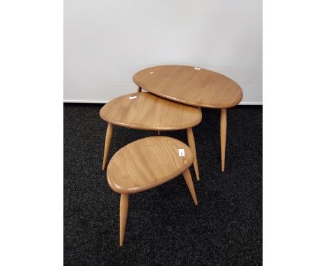 A Set of three vintage Ercol pebble tables. Showing blue sticker to the base and in a light elm wood. [Large table measures 4