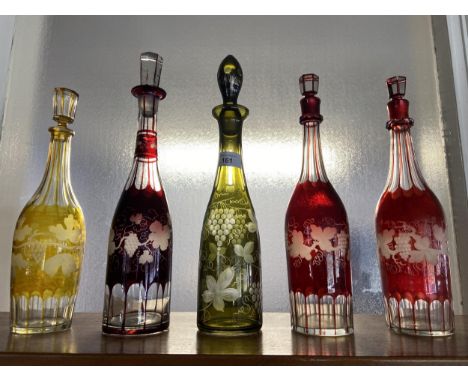 A Lot of five Antique Bohemian facet and etched decanters. Three in a Ruby red, One in a yellow and one in a green colour. Al
