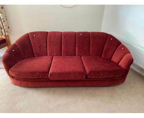 An Art Deco three seat sofa upholstered in a red material. 