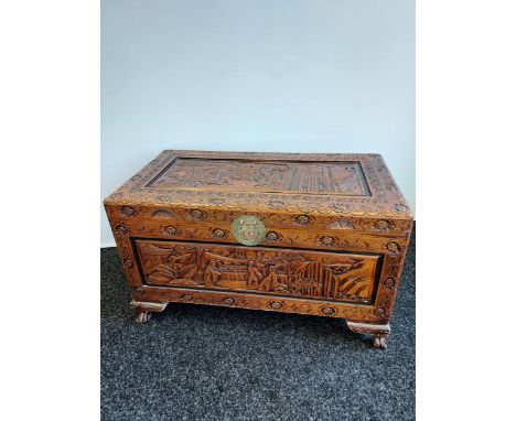 A Chinese hand carved camphor wood trunk. Panels depicting various figures and rural scenes. [60x102x53cm] 