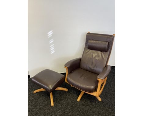 An Ercol brown leather and light wood relaxer arm chair with matching stool. 