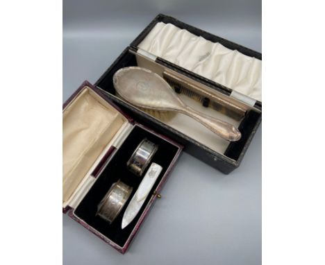 A Birmingham silver napkin ring set, Birmingham silver brush and comb set and a mother of pearl book mark. 