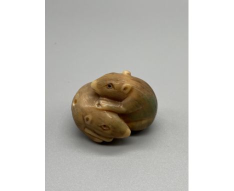 A Japanese hand carved tagua nut netsuke figure of two mice huddled together. Signed. 