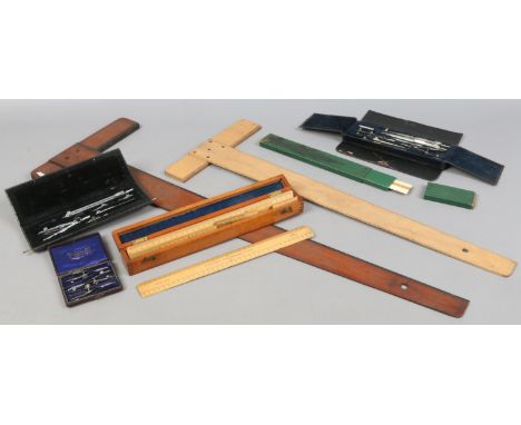 A quantity of Draughtmans equipment including early 20th century military wooden rulers, cased drawing tools, drawing board s