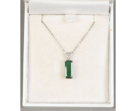 An 18ct white gold diamond and tourmaline pendant on chain.
