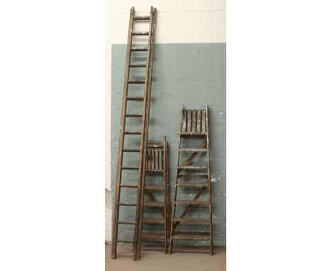 Two sets of wooden step ladders and two section wooden extending ladder.