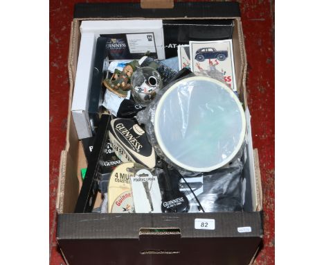 A box of Guinness memorabilia to include beer mats, glasses, Nokia 3310, postcards, enamel badges etc.