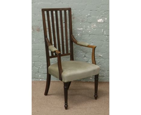 An Edwardian stick back oak arm chair with strung inlay and upholstered seat and arm rests, raised on turned supports.