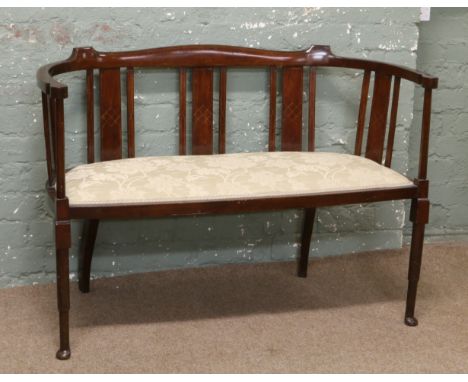 A Victorian mahogany salon sofa raised on pad foot legs.