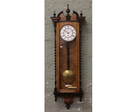 A 19th century walnut cased 8 day Vienna wall clock with ebonized bobbin turned decoration white enamel and brass dial, secon