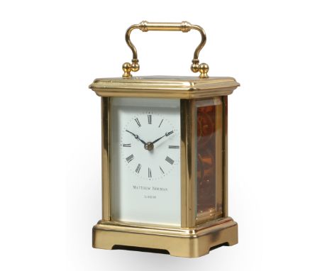 A brass carriage clock with white enamel dial and platform escapement by Matthew Norman of London with key.