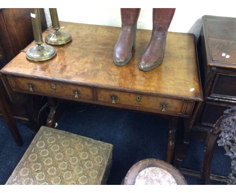 A reproduction walnut sofa table fitted with two drawers.