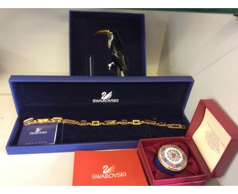 A boxed Swarovski toucan, and boxed Swarovski link bracelet set with coloured glass together with a modern Staffordshire enam