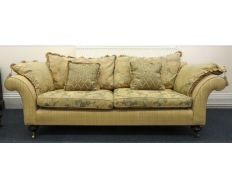 A large reproduction Victorian style upholstered sofa, with scroll arms, on turned gilt metal mounted legs and castors, havin