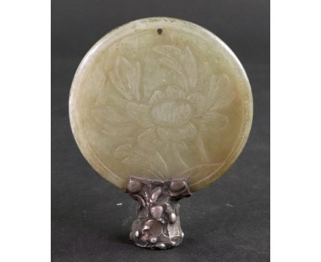 A Chinese circular jade disc, carved on one side with a flower and leaves, and the other characters symbolising 'double happi