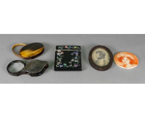 Two horn cased swivel magnifying glasses, 19th century, one oval 8.5cm wide, the other of shaped outline, 8cm wide, a Victori