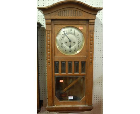 A 1930s oak drop trunk wall clock