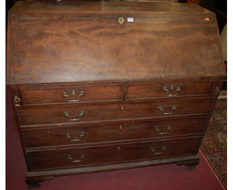 A George III mahogany slopefront writing bureau, having two short over three long graduated drawers, on bracket supports, w.1