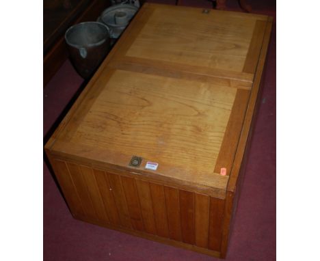 A light elm and oak low blanket box, raised on roller castors 