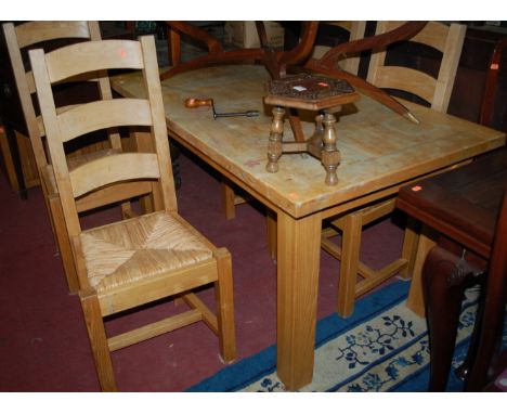 A light oak rectangular dining table; together with a set of four light oak ladderback and rushseat dining chairs (5)