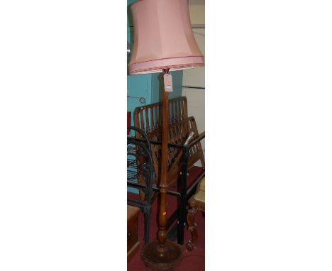 A mid-20th century walnut standard lamp, having a turned and reeded column 