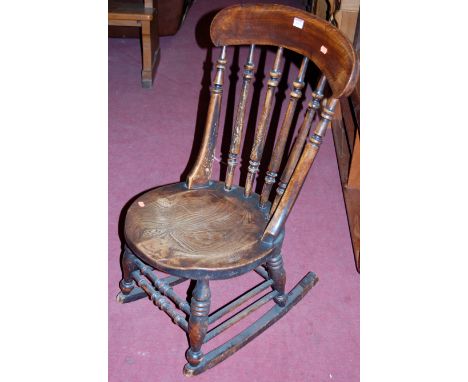 An early 20th century elm and beech stick back rocking chair