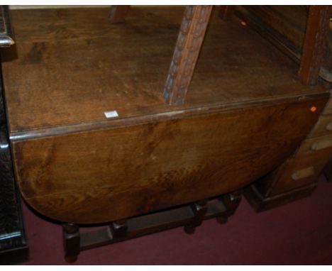 An early 20th century moulded oak drop leaf dining table having a gate leg action