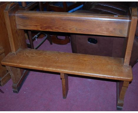 An early 20th century pitched pine two seater church pew, having an integral rear shelf raised on stepped end supports, width