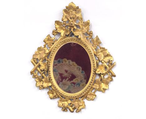 Late 19th century Italian Florentine oval giltwood wall mirror, with an oval plate to a leaf and berry naturalistic carved fr