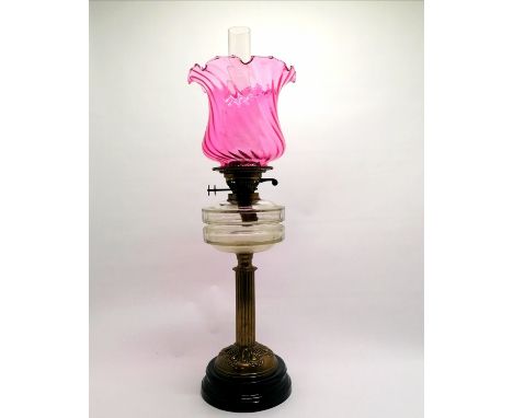 Antique oil lamp with brass column &amp; clear glass reservoir &amp; double duplex burner with a cranberry shade - 67cm total