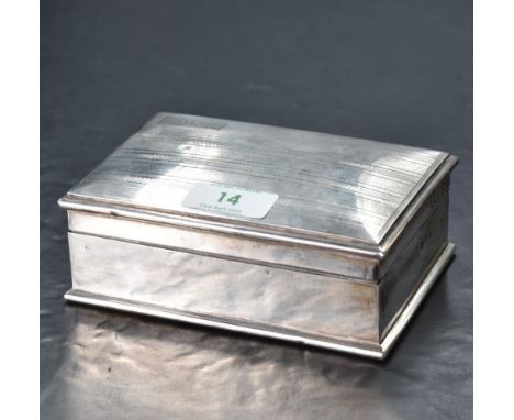 An early 20th century silver cigarette box, of hinged rectangular form with slightly domed cover with engine-turned decoratio